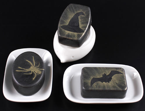 hree bars of Halloween soap. Black bars with glod mica stencil details.